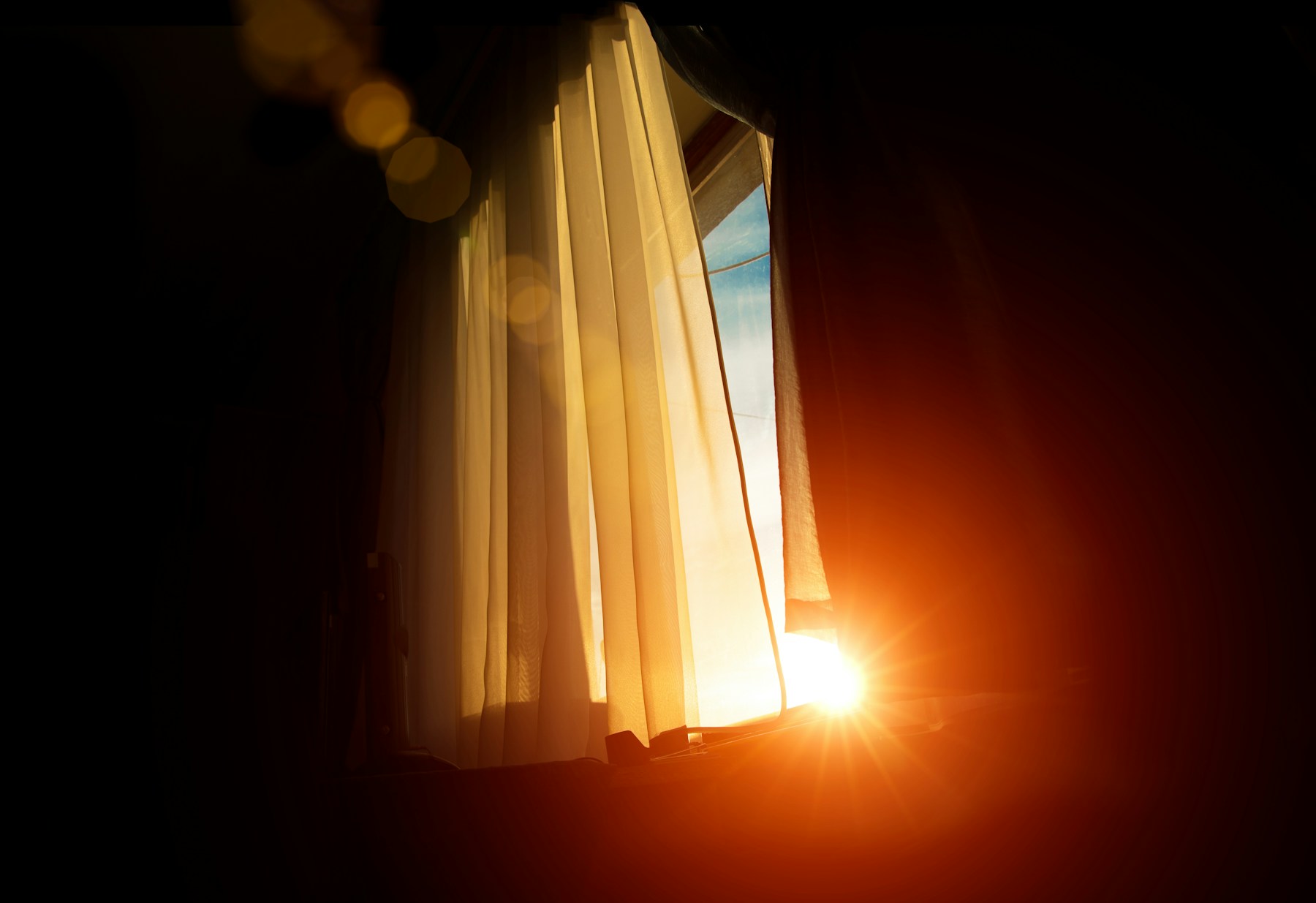 Golden morning light through a curtain